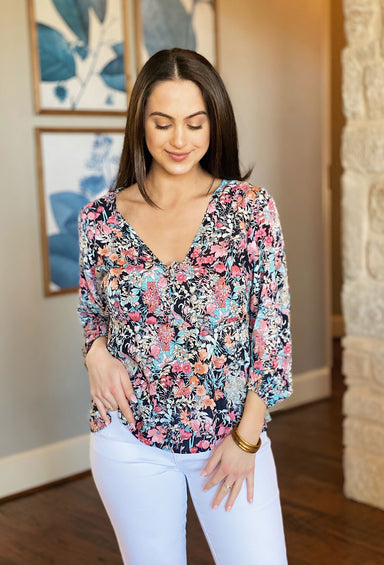 Samantha Floral Print Blouse, bright flower print throughout, this top has long elastic sleeves, and a v-neckline with button details