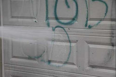 Demonstrating Tagaway removing graffiti from a garage door