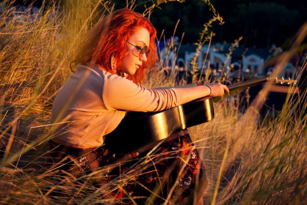 Redhead Playing Guitar In Nature ISA Professional