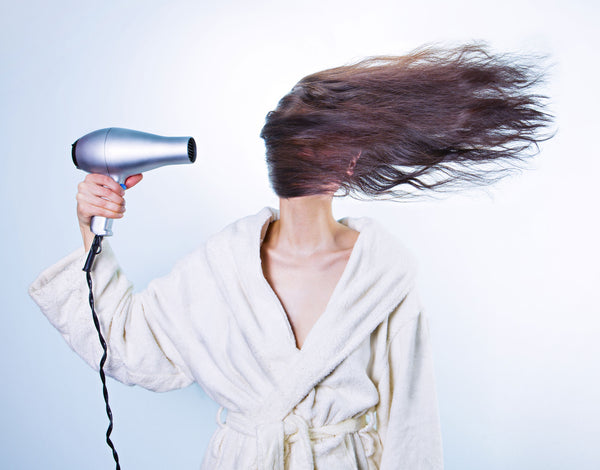 woman blow drying hair extensions