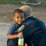 Uniformed man hugging small child