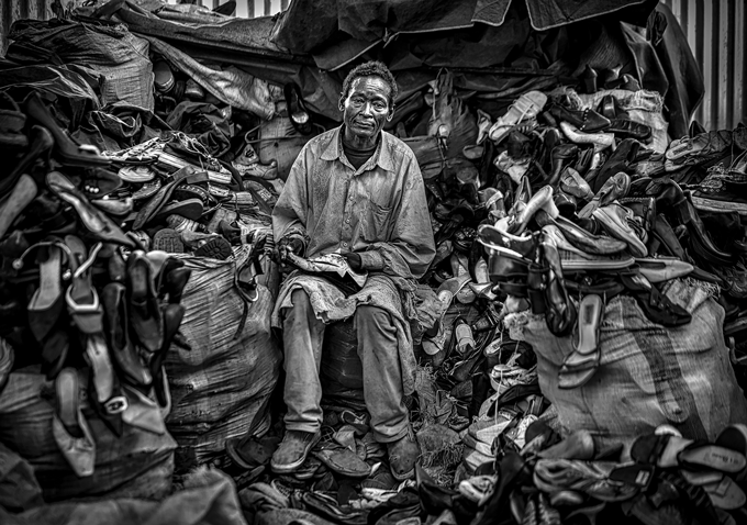 Image taken by Michael Schoenfeld of man surrounded by shoes 