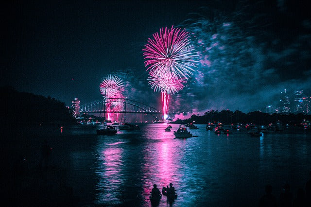 Fireworks on harbor with boats as silhouettes 