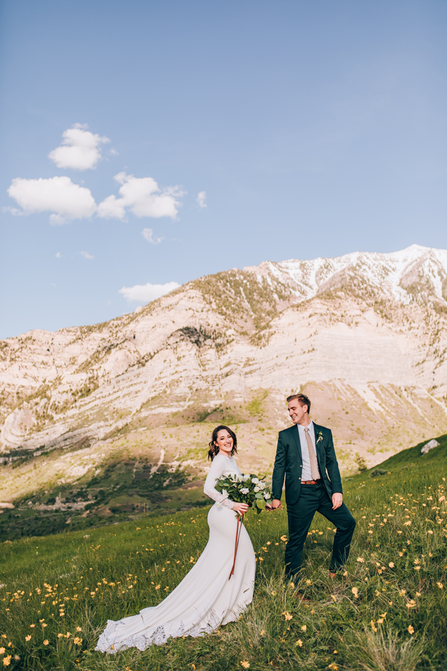 julia mathers photo of couple in wedding attire on hill
