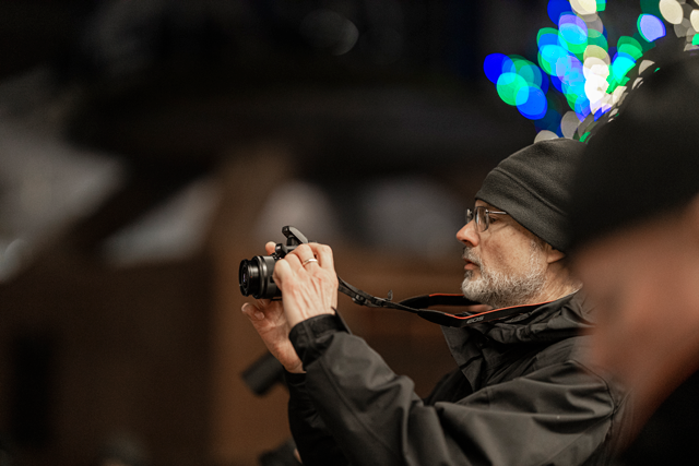 Man taking photo of holiday lights at pictureline event with canon camera