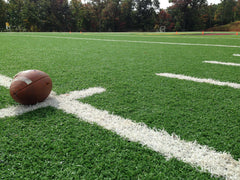 Football on green turf field - royalty free stock photo