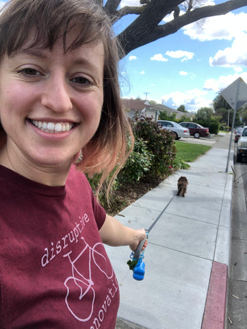 Selfie of mercedes while she walks her dog on a leash.
