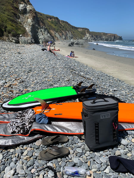 Surf boards and Yeti Hopper Backflip on the beach.