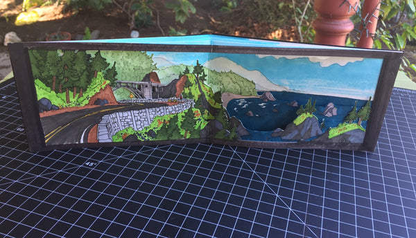 Pop up book illustrated with a biker riding over a road