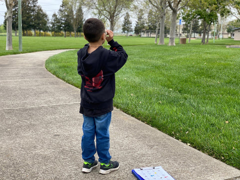 Mike's son holding his cardboard binoculars searching for items on his scavenger hunt.