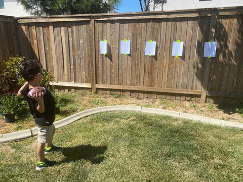 Aiden aiming a football at a letter.