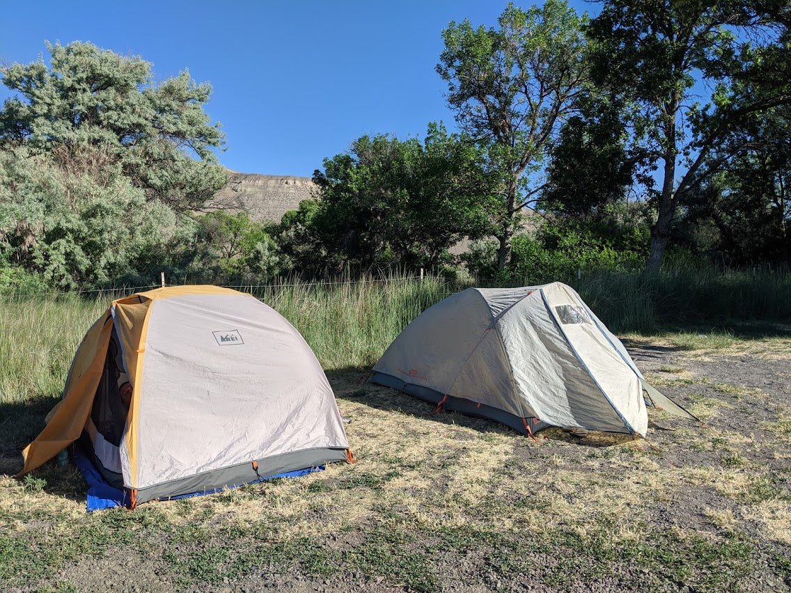Photo of two tents set up in a dispersed camping area at a boat launch.