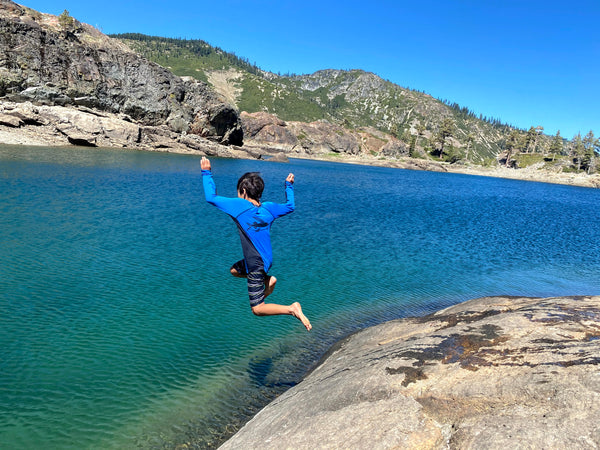 Susan's son jumping off a boulder