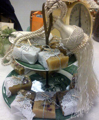 A vintage plate as part of the party favor display holds guest sized hand made soap. All wrapped to match the theme of the bridal shower.
