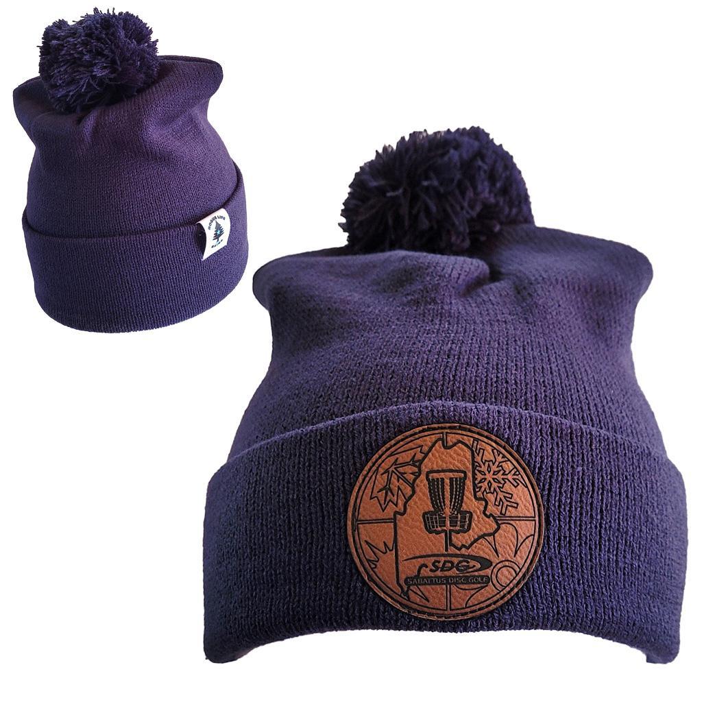 True Navy  Knit Pom Pom Beaning with SDG trainzwholesale Laser Engraved on leather patch that is sewn to the front of the hat, also a back view of the hat with the Rogue Life Maine logo on a small white tag sewn to the hat rim 