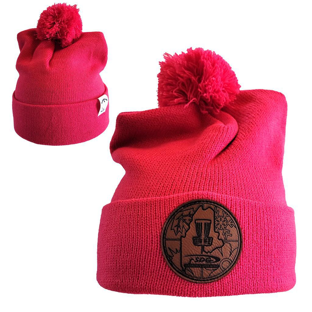 Pink Raspberry Colored  Knit Pom Pom Beaning with SDG trainzwholesale Laser Engraved on leather patch that is sewn to the front of the hat, also a back view of the hat with the Rogue Life Maine logo on a small white tag sewn to the hat rim 