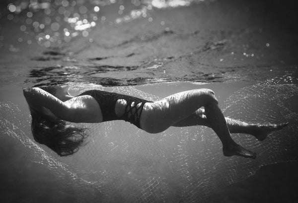 Manakai Swimwear black and white image of model underwater in one-piece kavakava