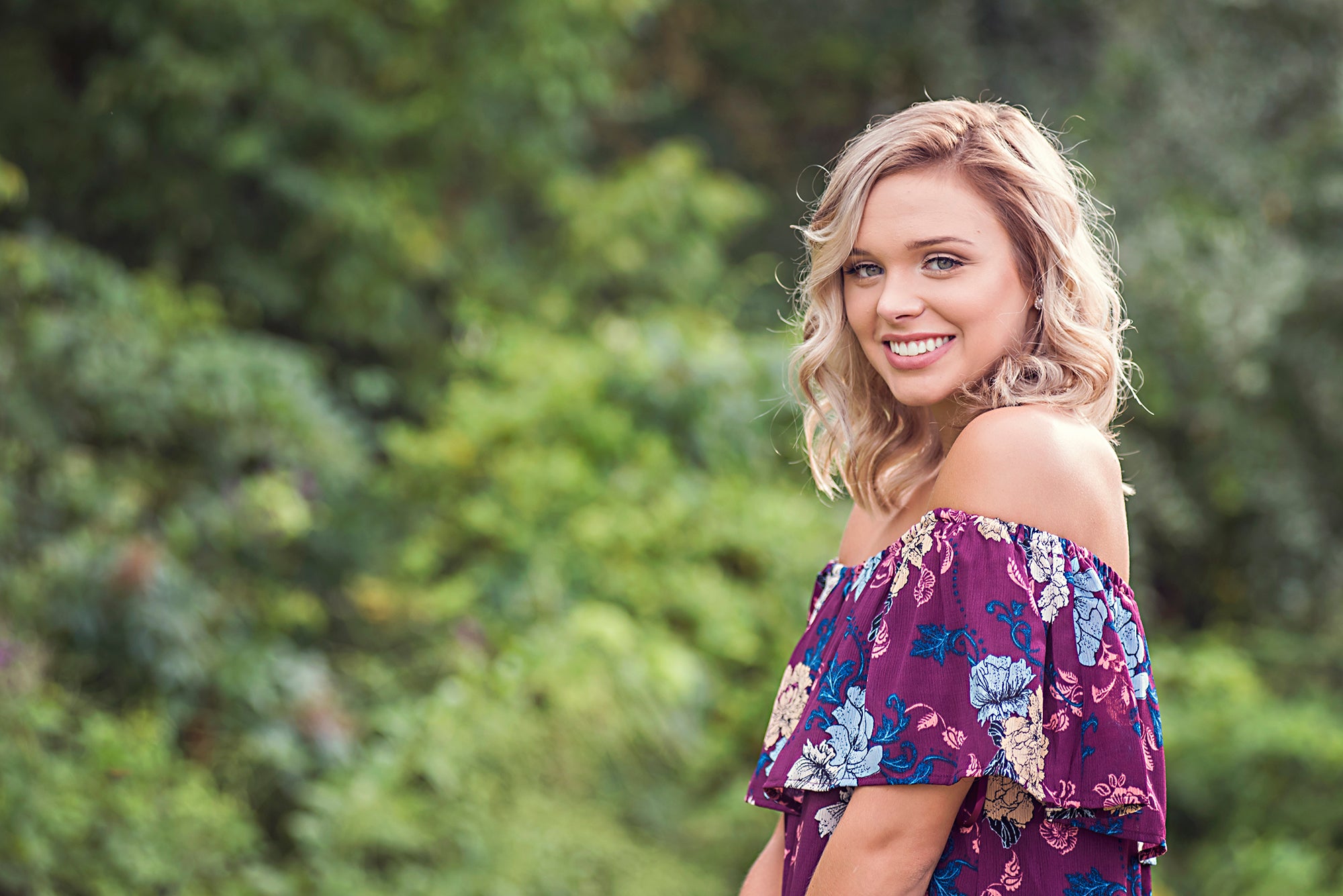 Model wearing floral off the shoulder dress.