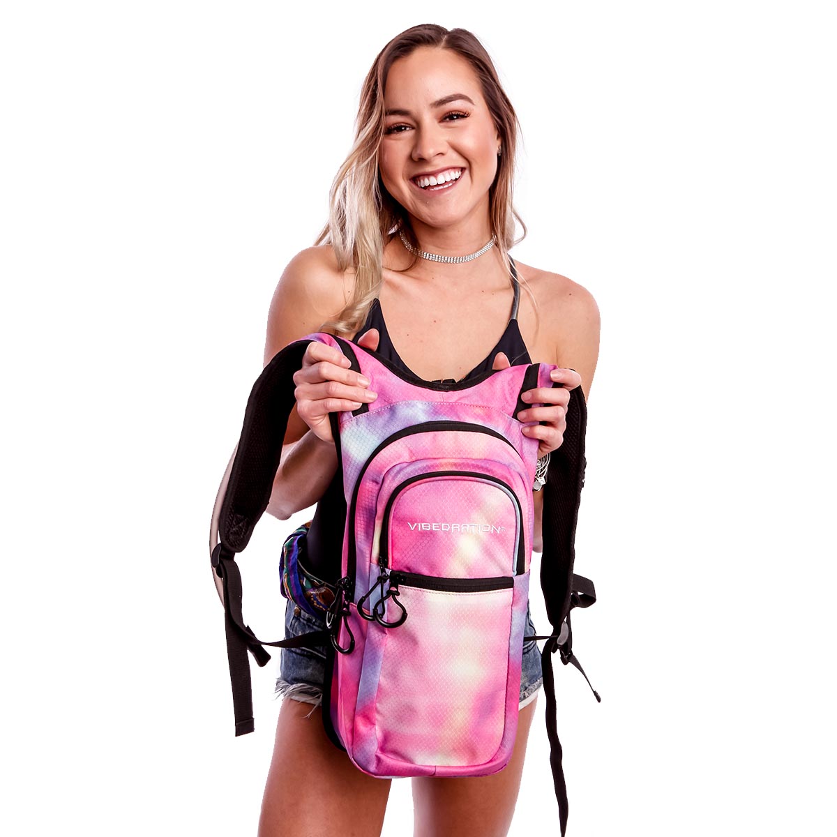 Female holding Tie-Dye Pink hydration pack with three pockets.