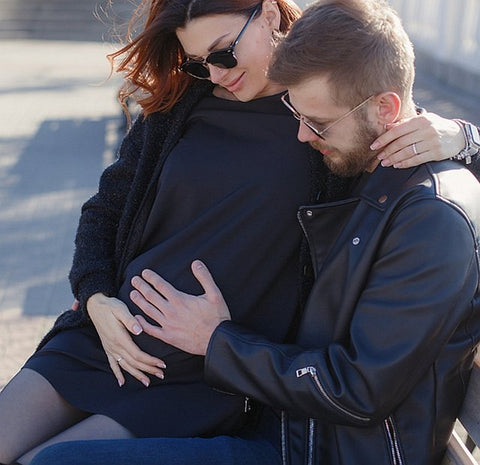 man and pregnant woman feeling baby bump