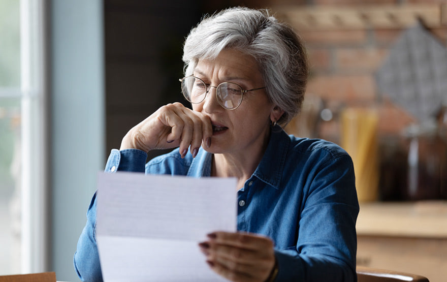 Distressed elderly woman checking documents