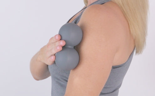 Woman massage using peanut ball in her shoulder