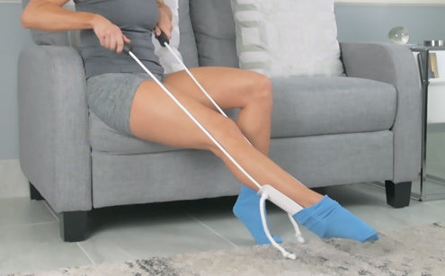 Woman using sock assist to wear socks