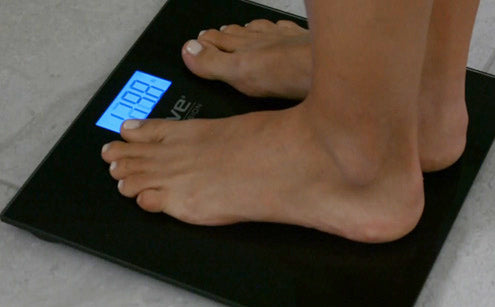 Stepping in digital bathroom scale showing accurate results