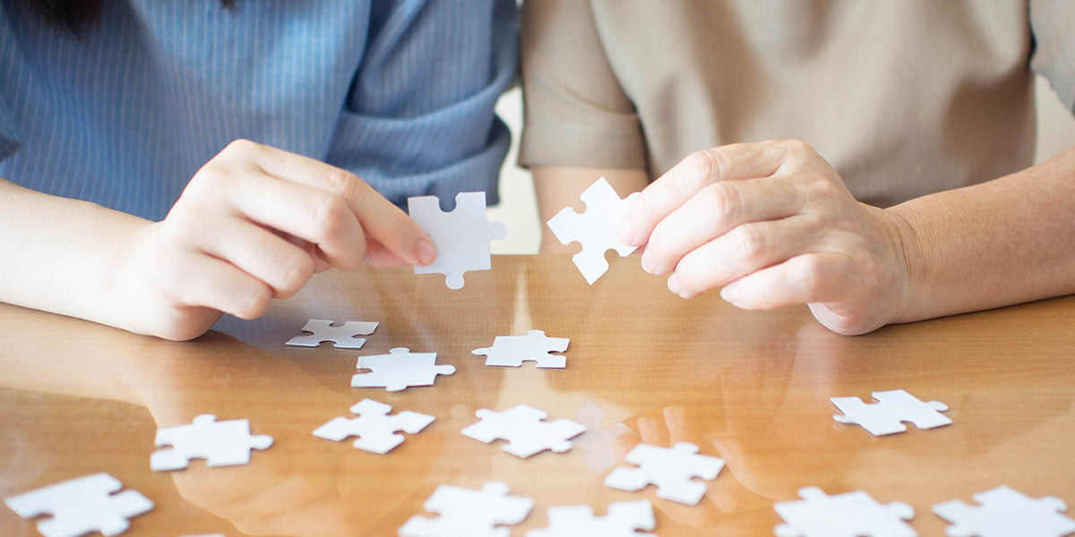 Elderly and young female playing jigsaw puzzle