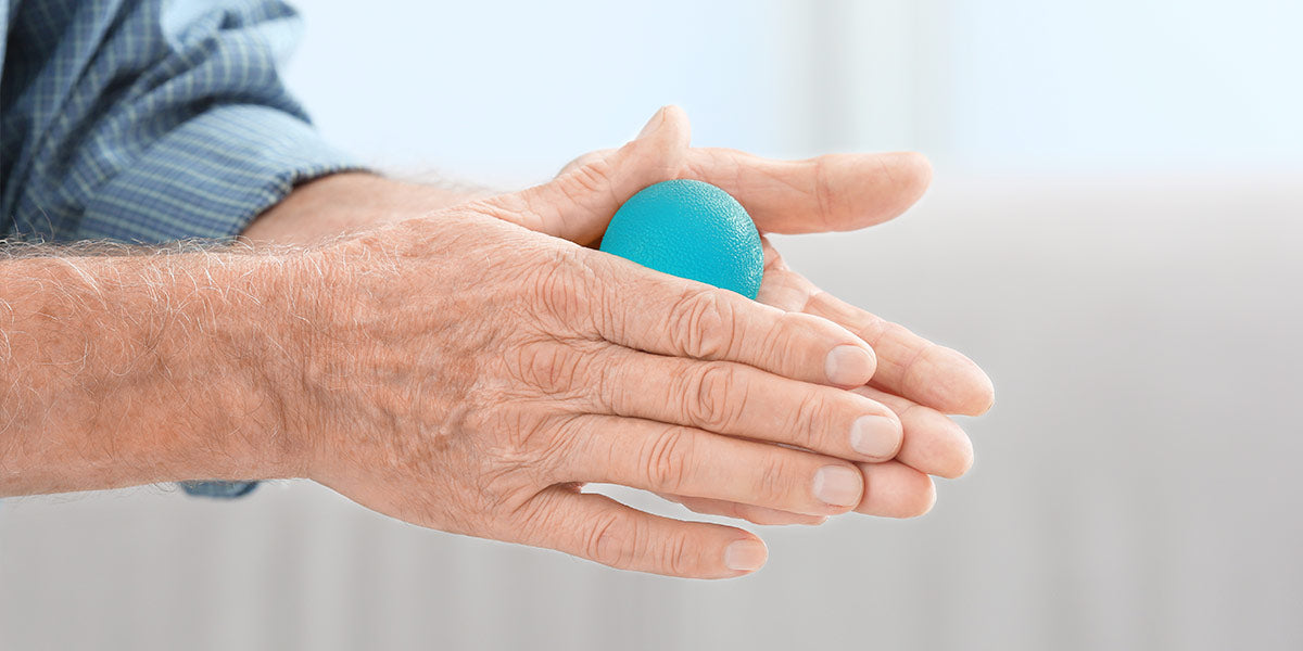 Hands of senior man doing exercise with rubber ball