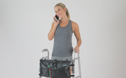 Middle age woman using phone holding walker