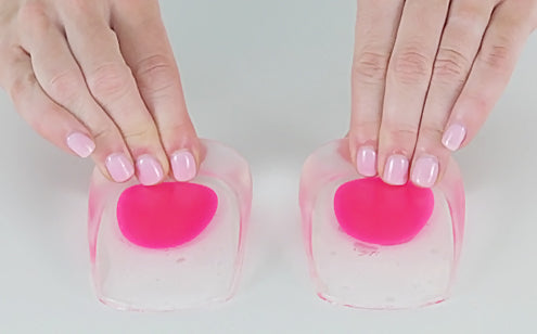 hands squeezing the gel of heel cups