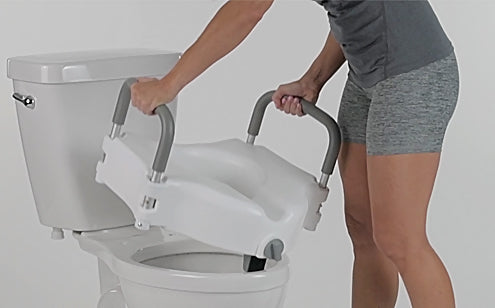 woman placing the raised toilet seat on toilet