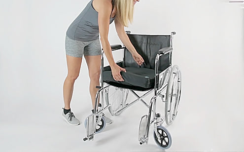 Woman placing cushion in a wheel chair