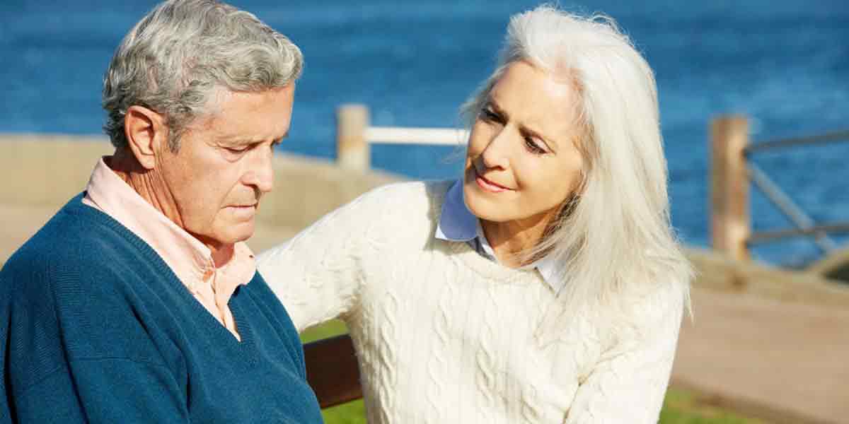 Senior-Woman Comforting Depressed Husband Sitting On Bench