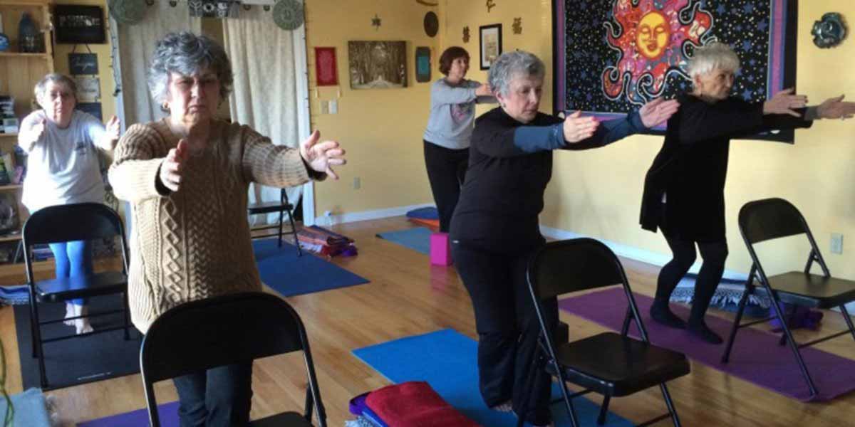 senior women doing chair yoga