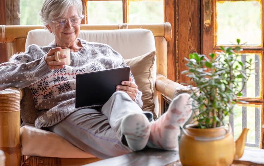 Smiling relaxed pensioner woman sitting at home