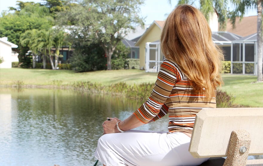 Woman sitting near a pond
