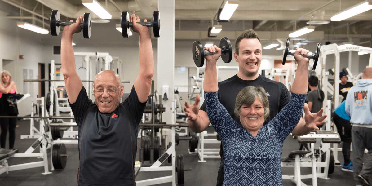 couple being trained to lift weights