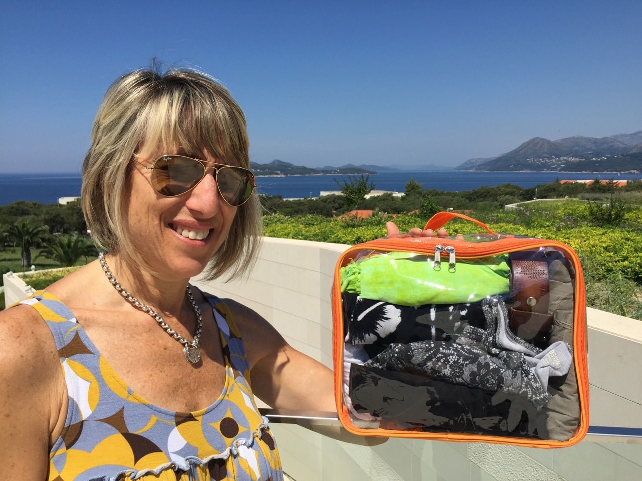 Woman holding an orange medium packing cube