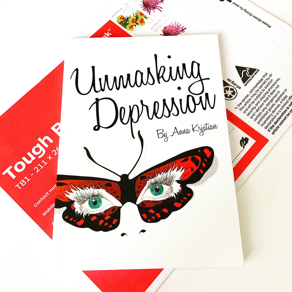 The book "Unmasking Depression" sits on top of a 'tough bag' package.