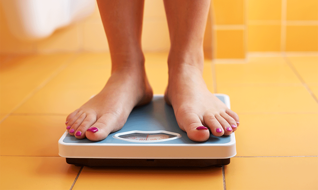 Woman Standing on Scale for Weight Loss