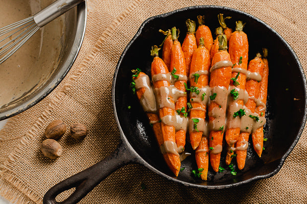 Savory roasted carrots in a skillet, drizzled with glaze. A delicious dish to get kids to eat their vegetables.