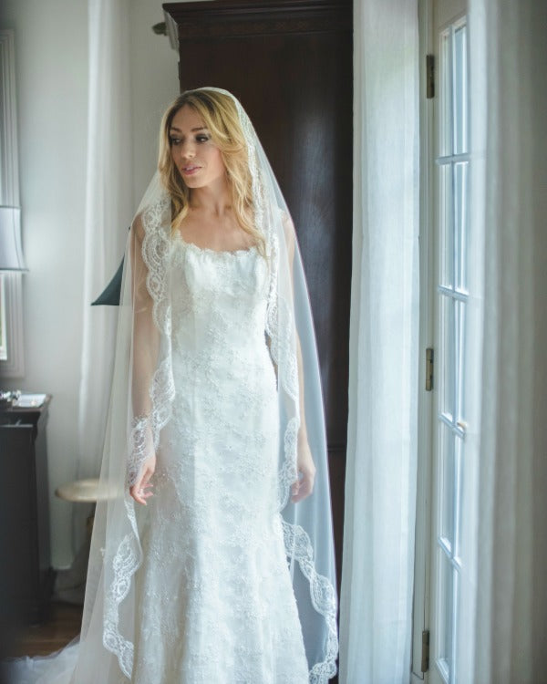 bride wearing cathedral length mantilla veil
