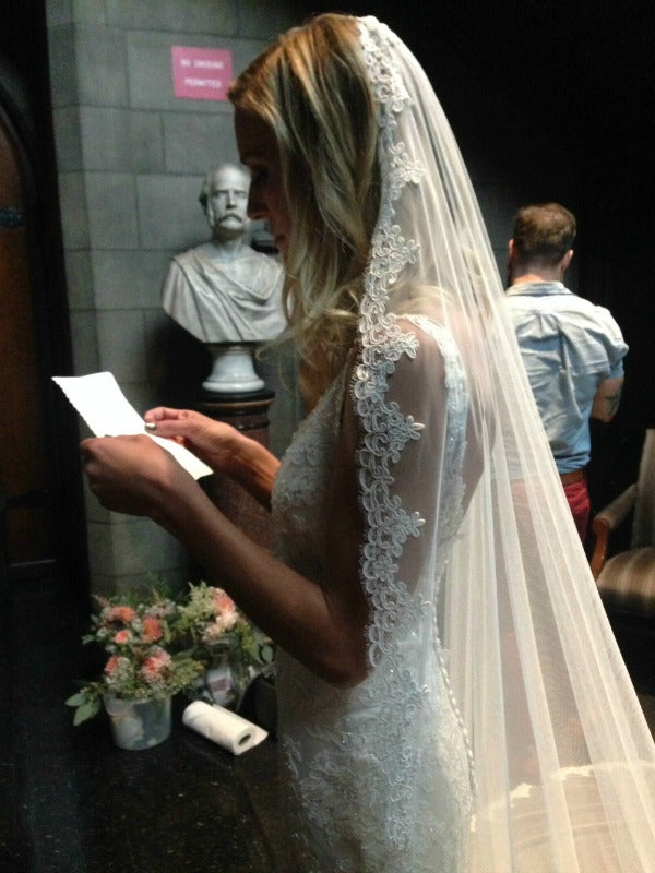 bride reading vows in mantilla veil