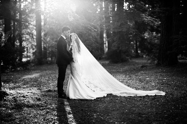 portrait of bride and groom in the forest with long veil