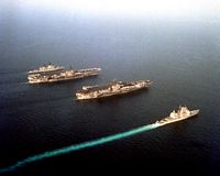 An aerial view of, from upper left, the guided missile cruiser USS BIDDLE (CG-34), the aircraft carriers USS SARATOGA (CV-60) and USS JOHN F. KENNEDY (CV-67) and the guided missile cruiser USS SAN JACINTO (CG-56) underway. After 45 days on station in support of Operation Desert Shield, the KENNEDY and its battle group are being relieved by the SARATOGA and its battle group. - 1990