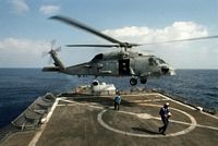 A flight crewman aboard the guided missile cruiser USS BIDDLE (CG-34) disconnects a sling lowered from an SH-60B Sea Hawk helicopter. The BIDDLE is deployed in support of Operation Desert Shield. - 1990