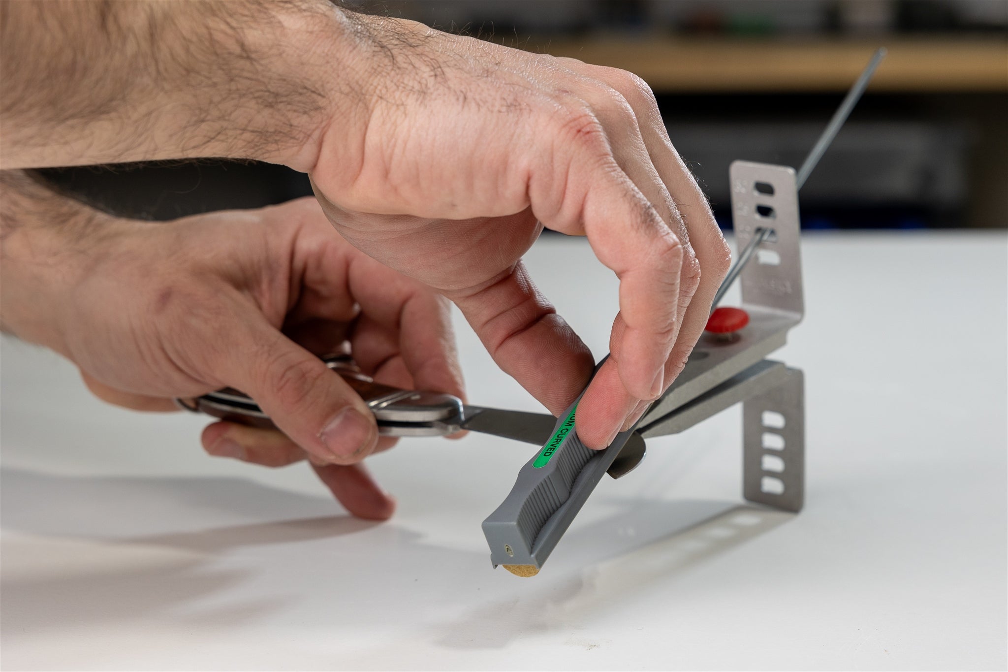 A curved knife being sharpened with the Lansky Curved Blade Hone and Lansky guided knife sharpener.