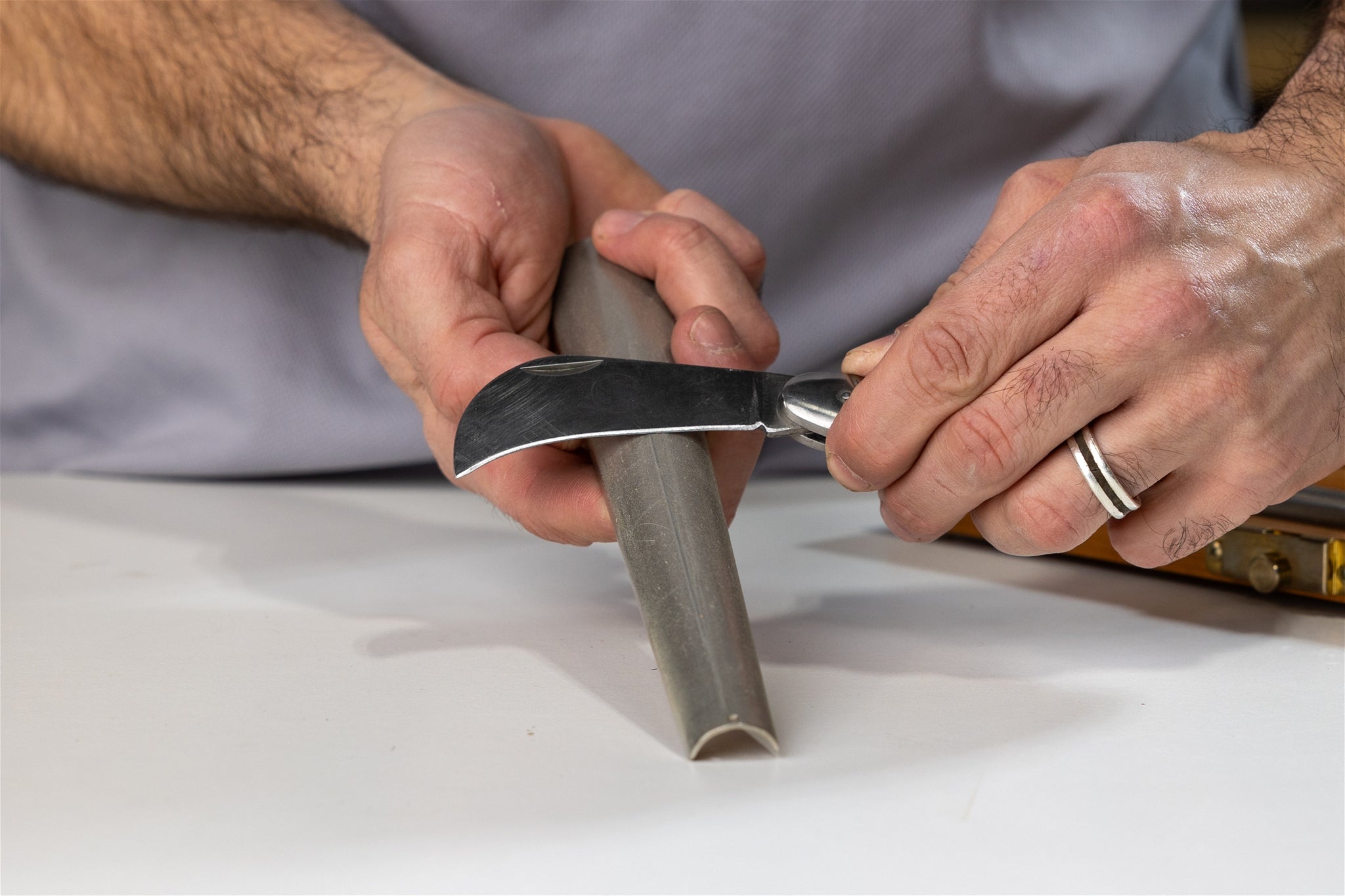 A curved knife being sharpened on a large DMT Diamond Cone.